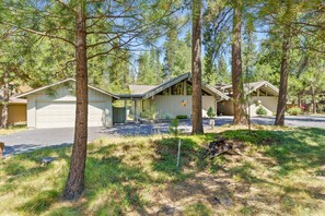 A residential property with two detached houses, each with a garage, surrounded by a forested area.