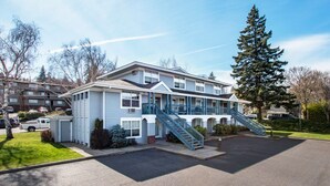 A two-story motel with a central staircase, a covered porch, and a parking lot. - Comfortable 09 Lodge Condo Minutes Away from Downtown Hood River by RedAwning (Hood River)