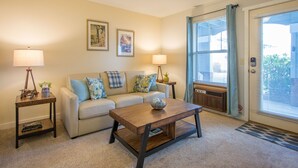 A living room with a sofa, coffee table, two lamps, and framed pictures on the wall. - Comfortable 09 Lodge Condo Minutes Away from Downtown Hood River by RedAwning (Hood River)
