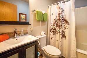 A bathroom with a white sink, a toilet, a shower curtain with a tree design, and a green towel hanging on the wall. - Comfortable 09 Lodge Condo Minutes Away from Downtown Hood River by RedAwning (Hood River)