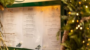 Un panneau affichant le menu, avec différents plats et leurs prix, placé dans un restaurant.
