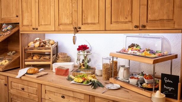Un buffet en bois, avec divers plats et un panneau indicateur en ardoise.