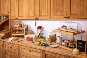 A wooden buffet setup with various food items and a chalkboard sign.