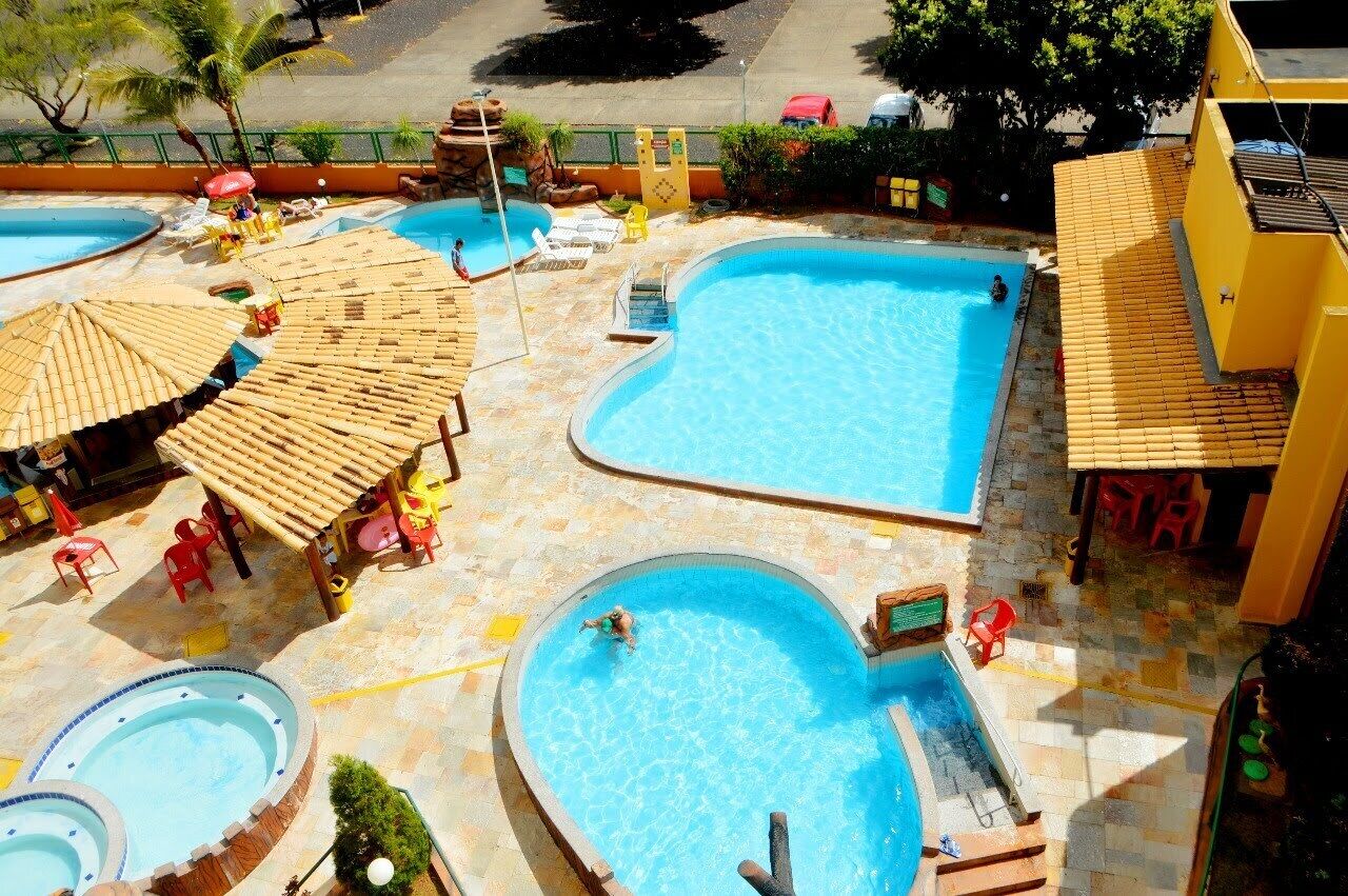 A pool area with multiple swimming pools, sun loungers, and umbrellas.