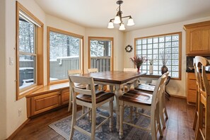 A spacious kitchen with large windows, wooden cabinetry, and a dining table with chairs. - 9 Hoodoo Home with XBOX 360 and Private Hot Tub by RedAwning (Bend)