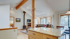 A spacious kitchen with wooden cabinets, a granite countertop, and a dining area with a table and chairs. - 7 Cedar Private Cul-de-sac include Hot Tub with Forest View by RedAwning (Bend)