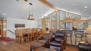A spacious living room with a dining area, wooden furniture, and large windows. - 2 Sarazen Home with Hot Tub and BBQ on the Deck, Close to Woodlands Golf Course by RedAwning (Bend)