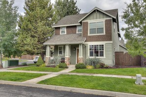 Stunning two-story home with a charming front porch and beautifully manicured lawn.