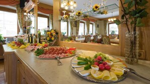 Una mesa de buffet con diversos alimentos y cristalería.