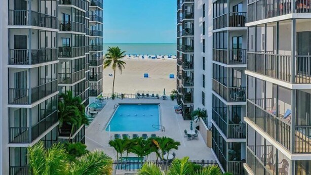 A high-rise hotel with a swimming pool, beach view, and balconies. - Beautiful Beachfront condo with Gulf View FALL SPECIAL 20% OFF ANY RES TIL 10/31 (Fort Myers Beach)