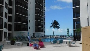 A rooftop pool area with lounge chairs and a view of the ocean. - Beautiful Beachfront condo with Gulf View FALL SPECIAL 20% OFF ANY RES TIL 10/31 (Fort Myers Beach)