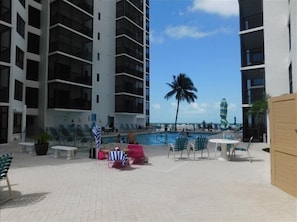 Uma área de piscina no terraço com espreguiçadeiras e vista para o oceano.