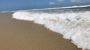 A beach with waves crashing onto the shore under a clear sky. - Beautiful luxury apartment, 3 suites, 55" TV, swimming pools, air conditioning, complete, 400m from the beach, cond. (Aquiraz)
