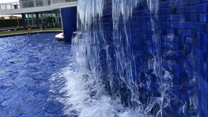 A large indoor water feature with a cascading waterfall, surrounded by a pool. - Beautiful luxury apartment, 3 suites, 55" TV, swimming pools, air conditioning, complete, 400m from the beach, cond. (Aquiraz)