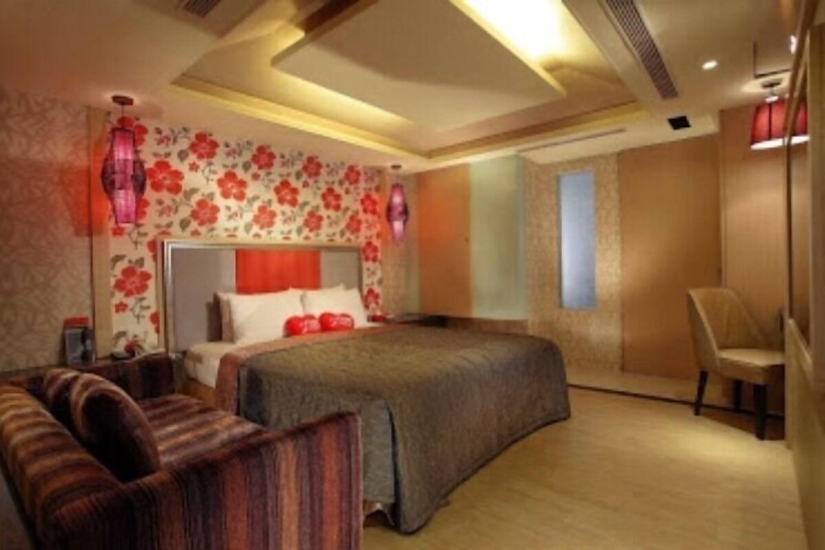 Une chambre à coucher avec un lit, une table de chevet, une chaise et un canapé.