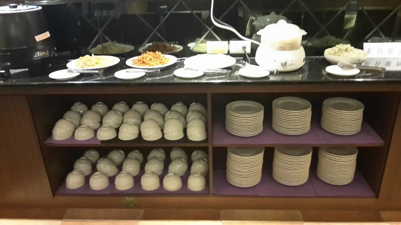 A buffet counter with various dishes and bowls of food.