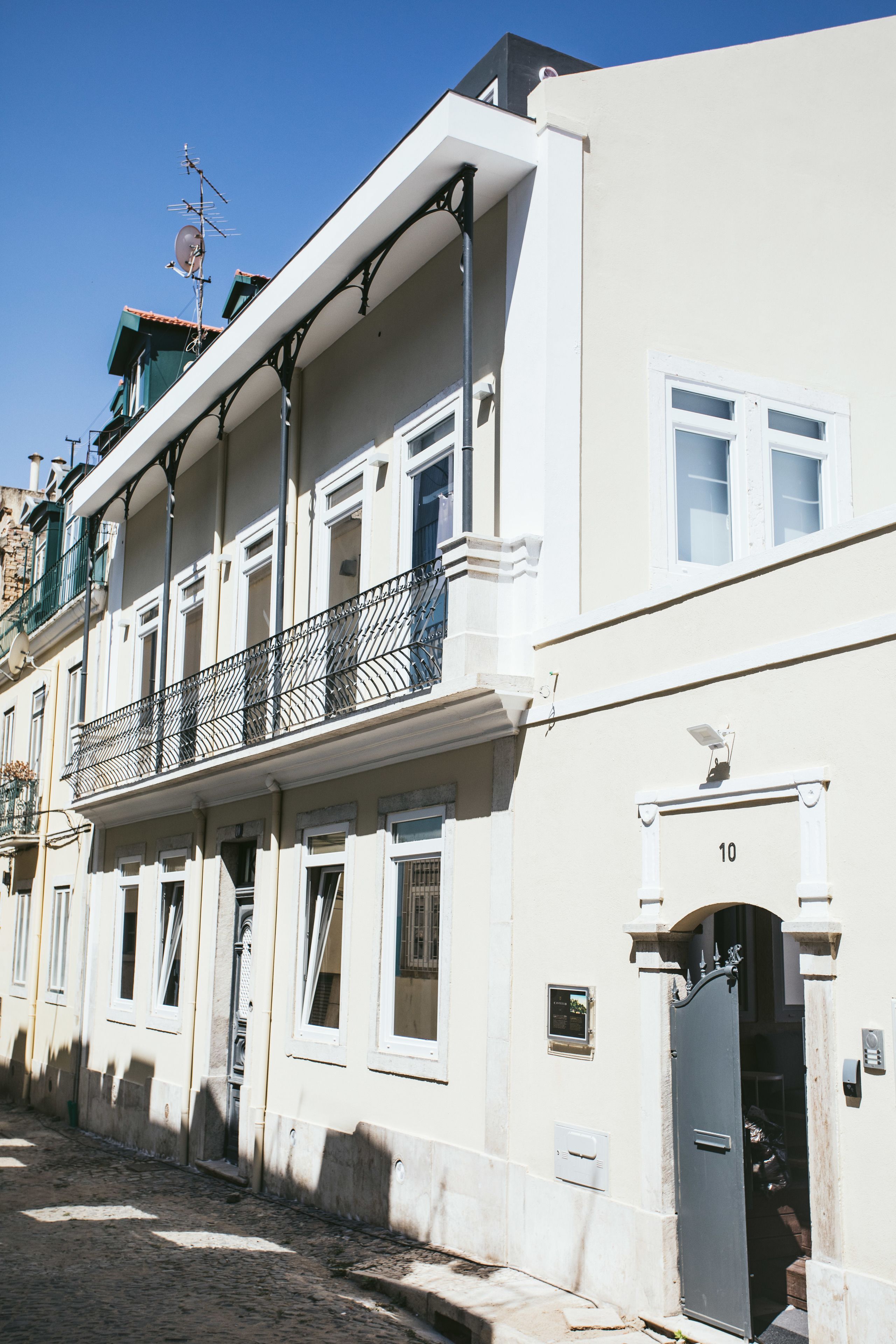 A multi-story building with a balcony, a door labeled "10", and a satellite dish.