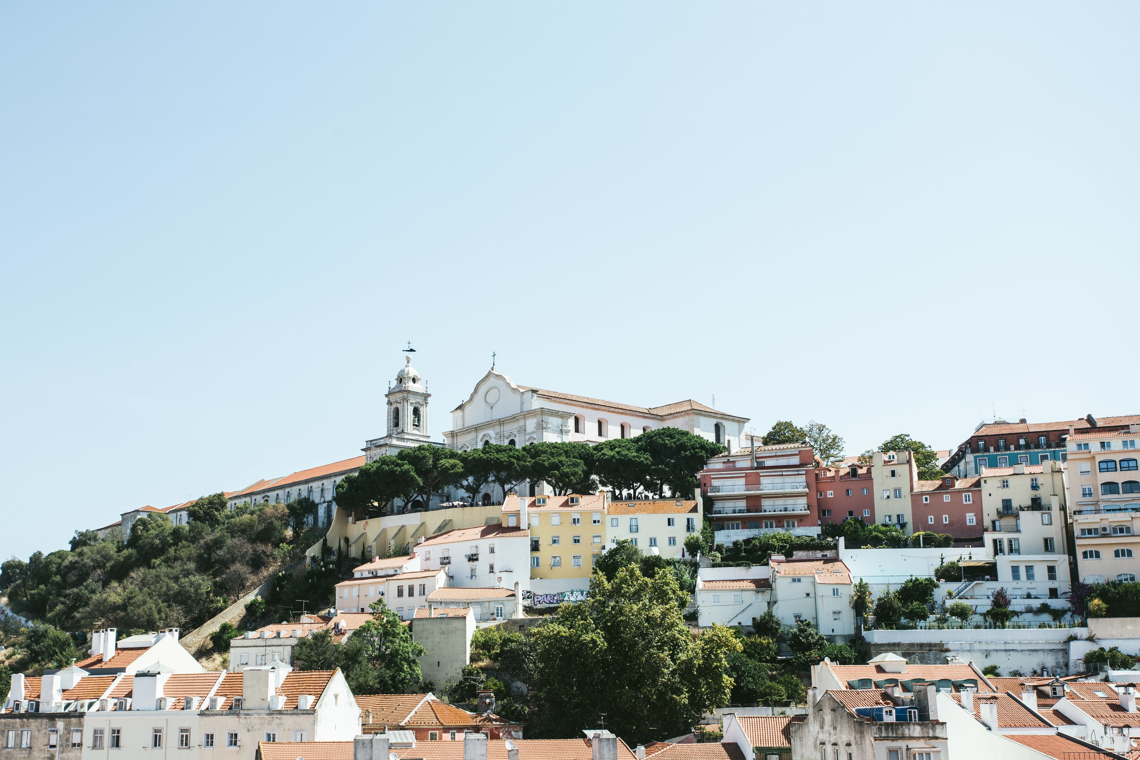 A hillside town with historic buildings, a prominent church, and a mix of residential and commercial structures.