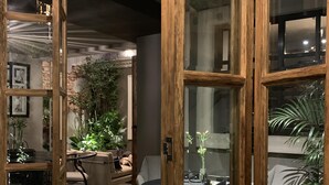 Un interior moderno con comedor, asientos y vistas a través de un ventanal de madera.