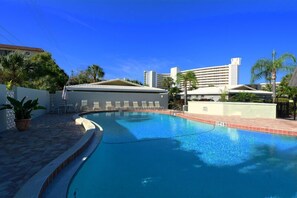 Relax by the rectangular pool surrounded by a tiled deck and lounge chairs.