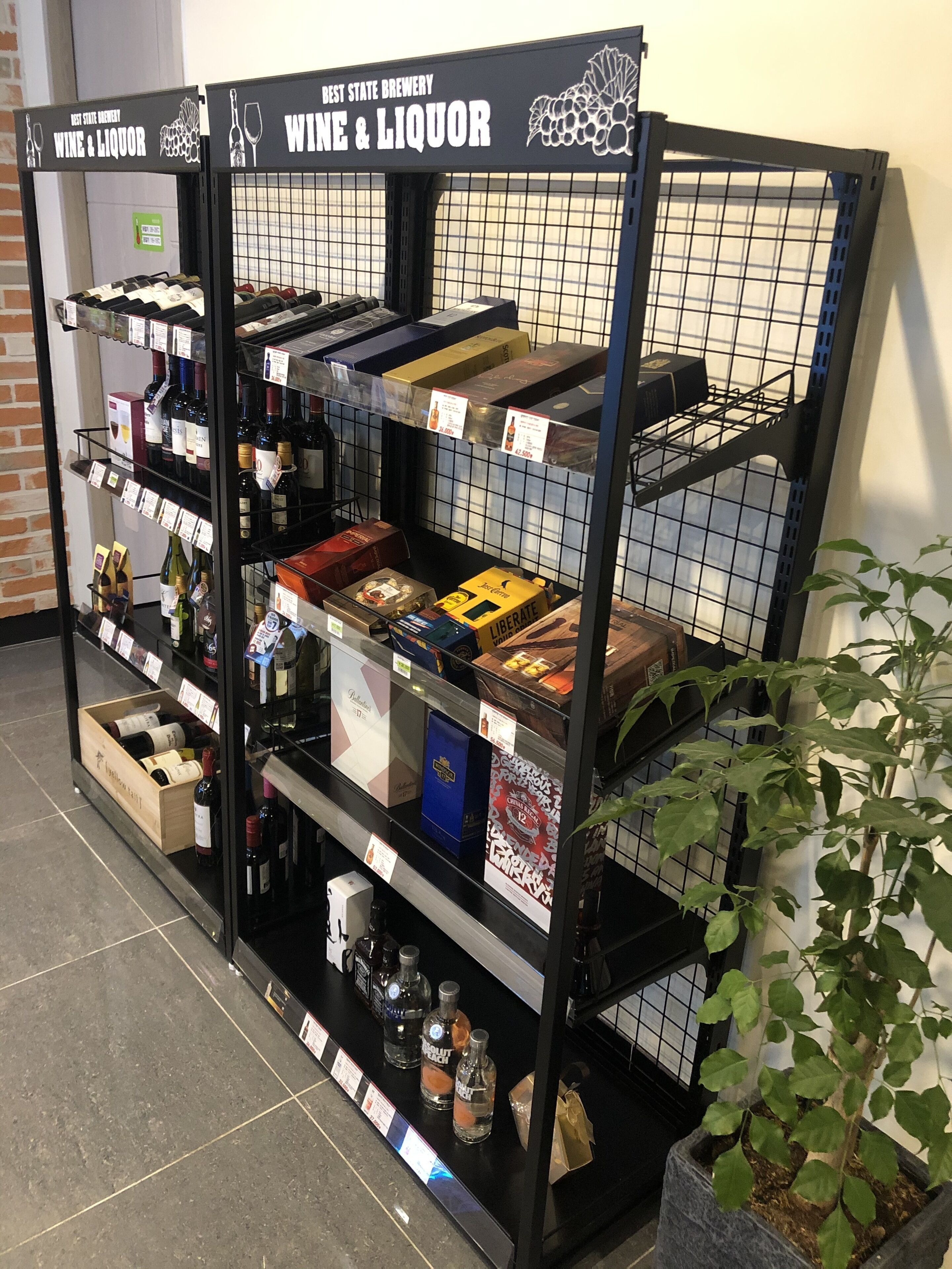 Exhibición de vinos y licores con varias botellas y cajas, incluyendo una caja azul con la etiqueta 'Liberate' y una caja con caracteres chinos.
