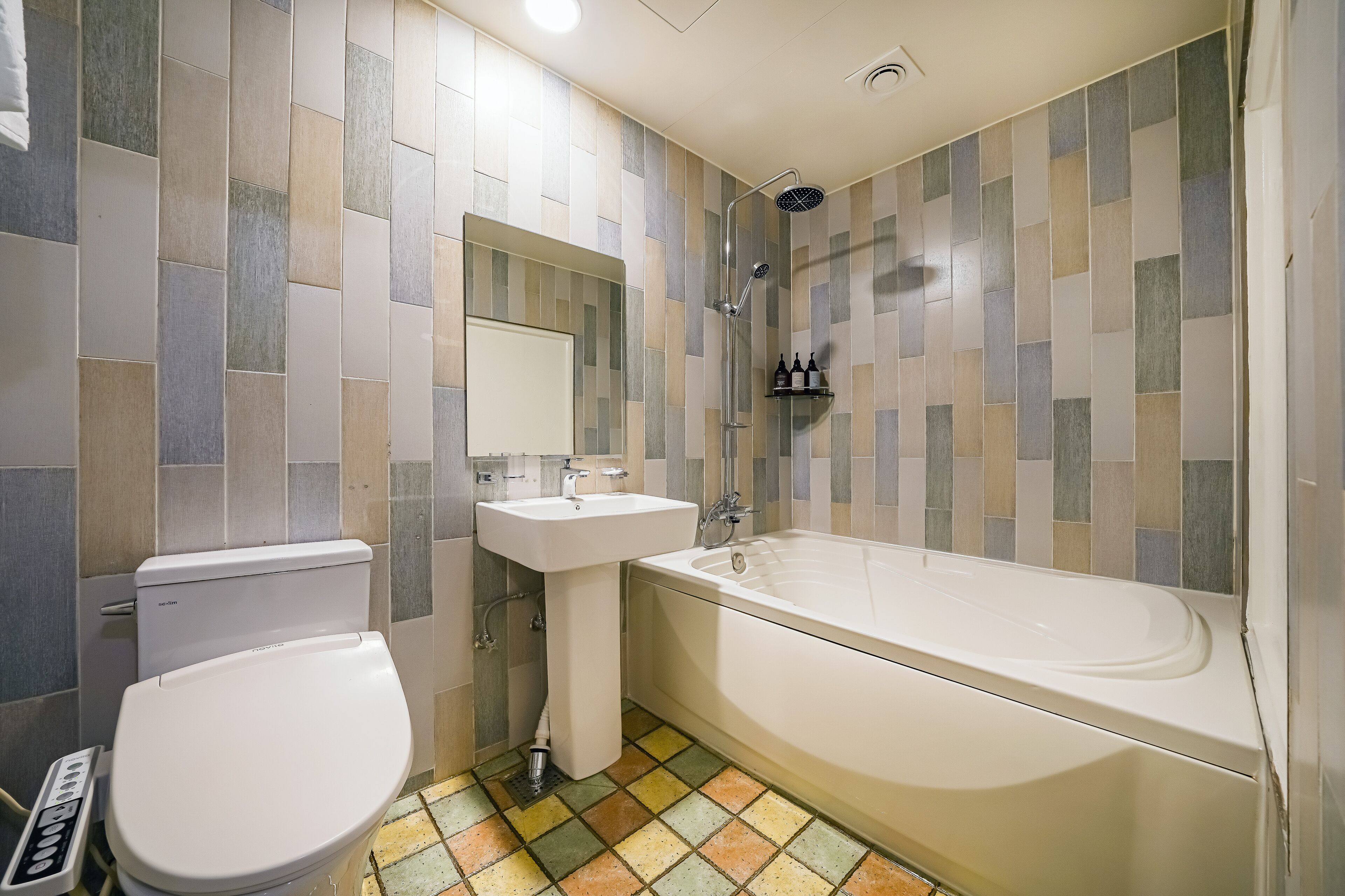 A bathroom with a toilet, sink, and bathtub.
