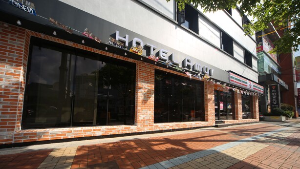 A hotel with a modern facade, large windows, and a brick exterior. - Masan Amor Hotel (Changwon)
