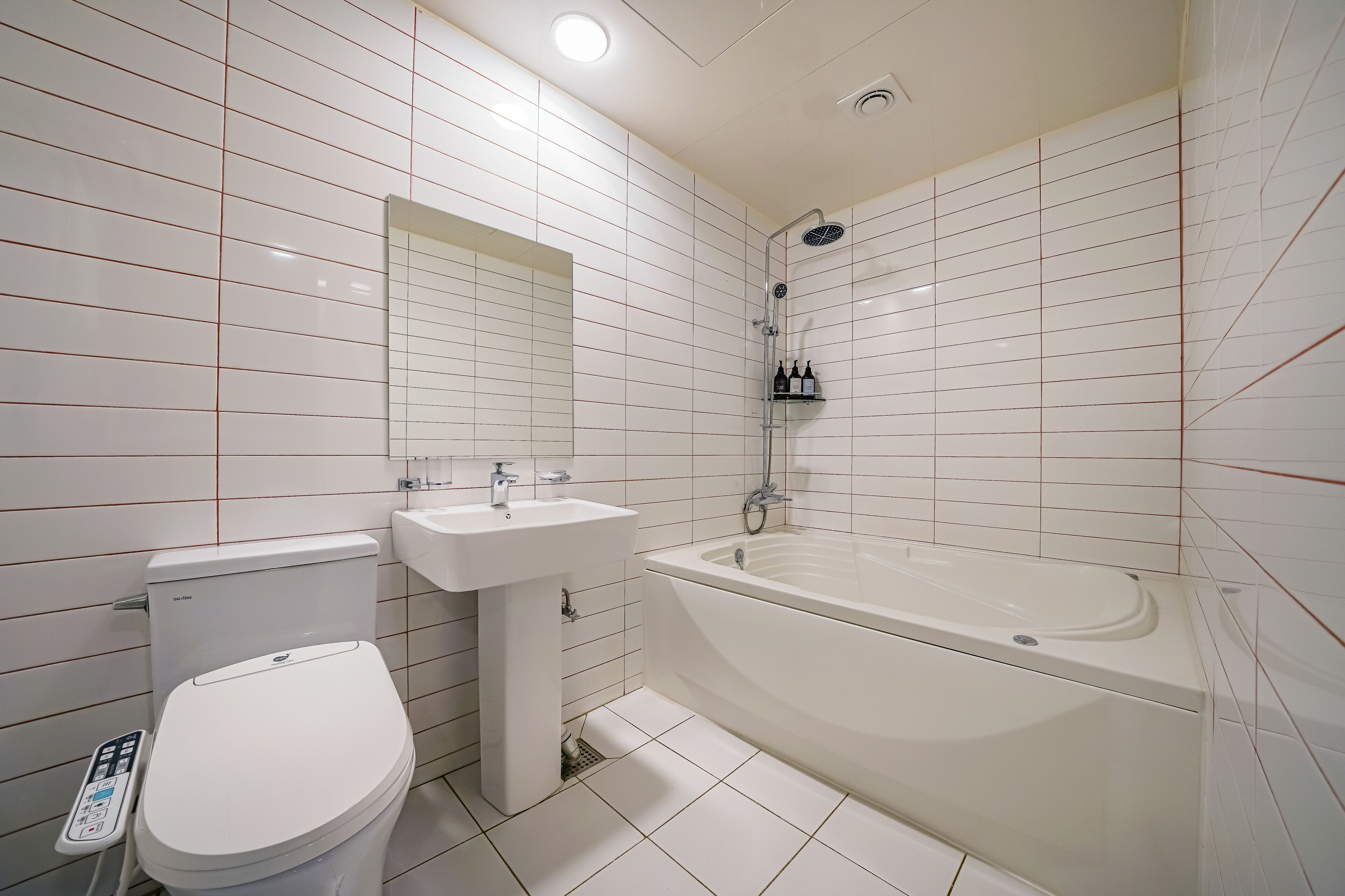 Un baño moderno con inodoro, lavamanos y bañera.
