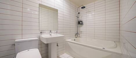 Un baño moderno con inodoro, lavamanos y bañera.