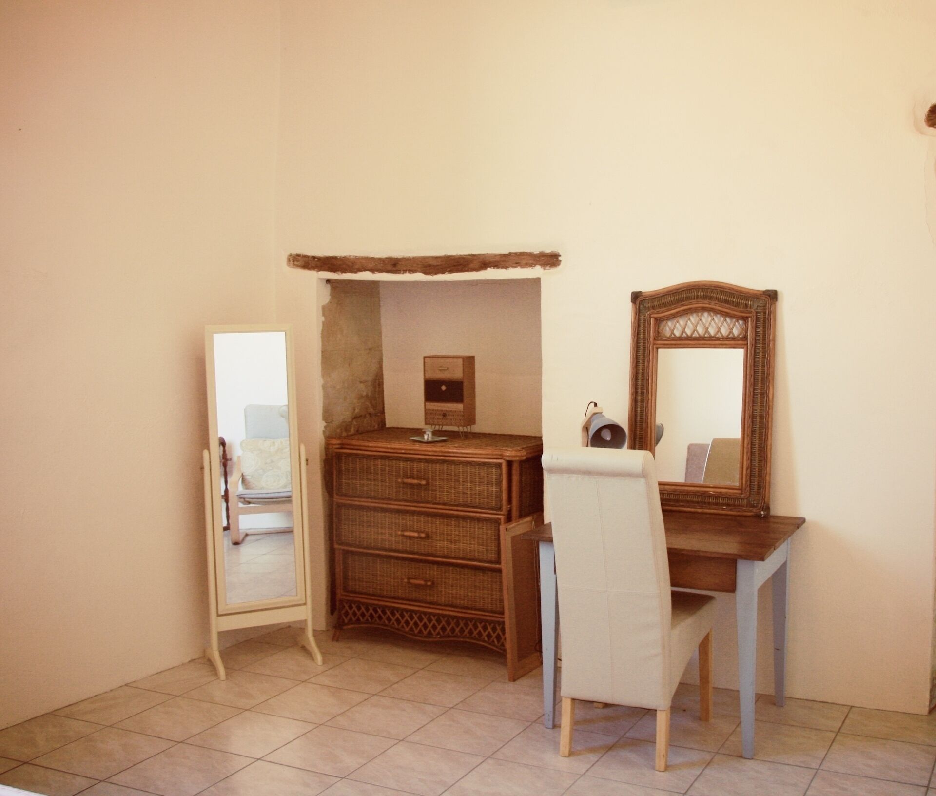 Une pièce comprenant une commode en bois, un miroir et une chaise.