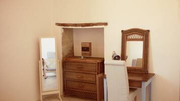 Une pièce comprenant une commode en bois, un miroir et une chaise.