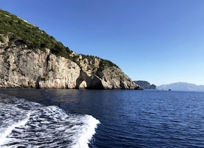 Un paisaje costero con acantilados rocosos y un mar azul transparente.
