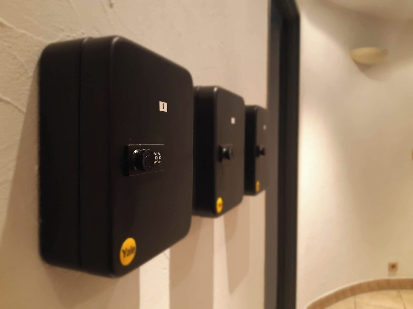 Dispositivo de seguridad fijado a la pared, con teclado y cerradura.