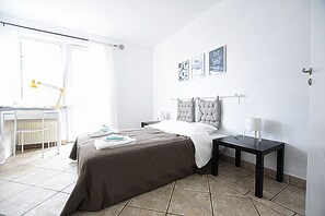 A bedroom with a bed, bedside tables, a desk, and a chair. - Mhost Bronowice (Kraków)