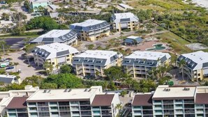 A coastal resort with multiple buildings, a beach, and a clear view of the ocean. - Loggerhead Cay 562 - Partial gulf view, beach side vacation rental condo (Sanibel)