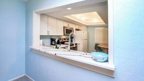 A modern kitchen with white cabinets, a built-in microwave, and a sink with a faucet. - Loggerhead Cay 562 - Partial gulf view, beach side vacation rental condo (Sanibel)