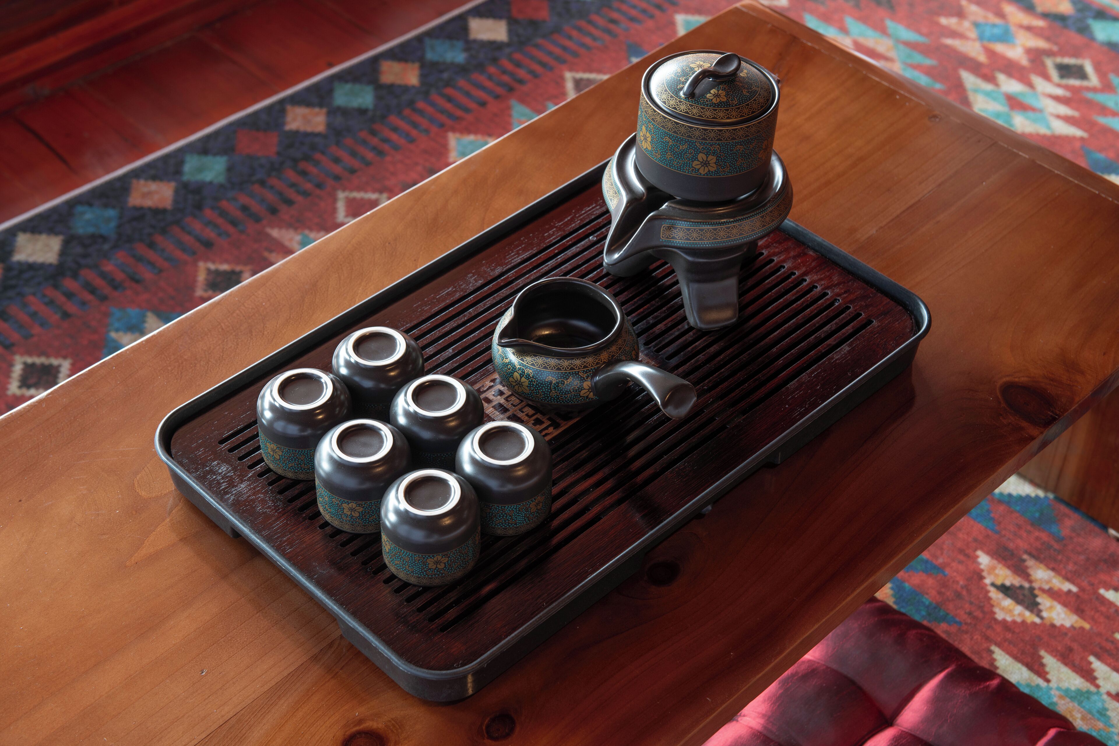 A tray with tea utensils on a wooden table.