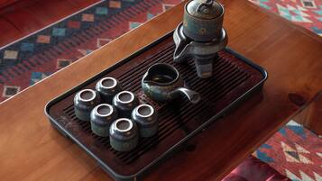 A tray with tea utensils on a wooden table.