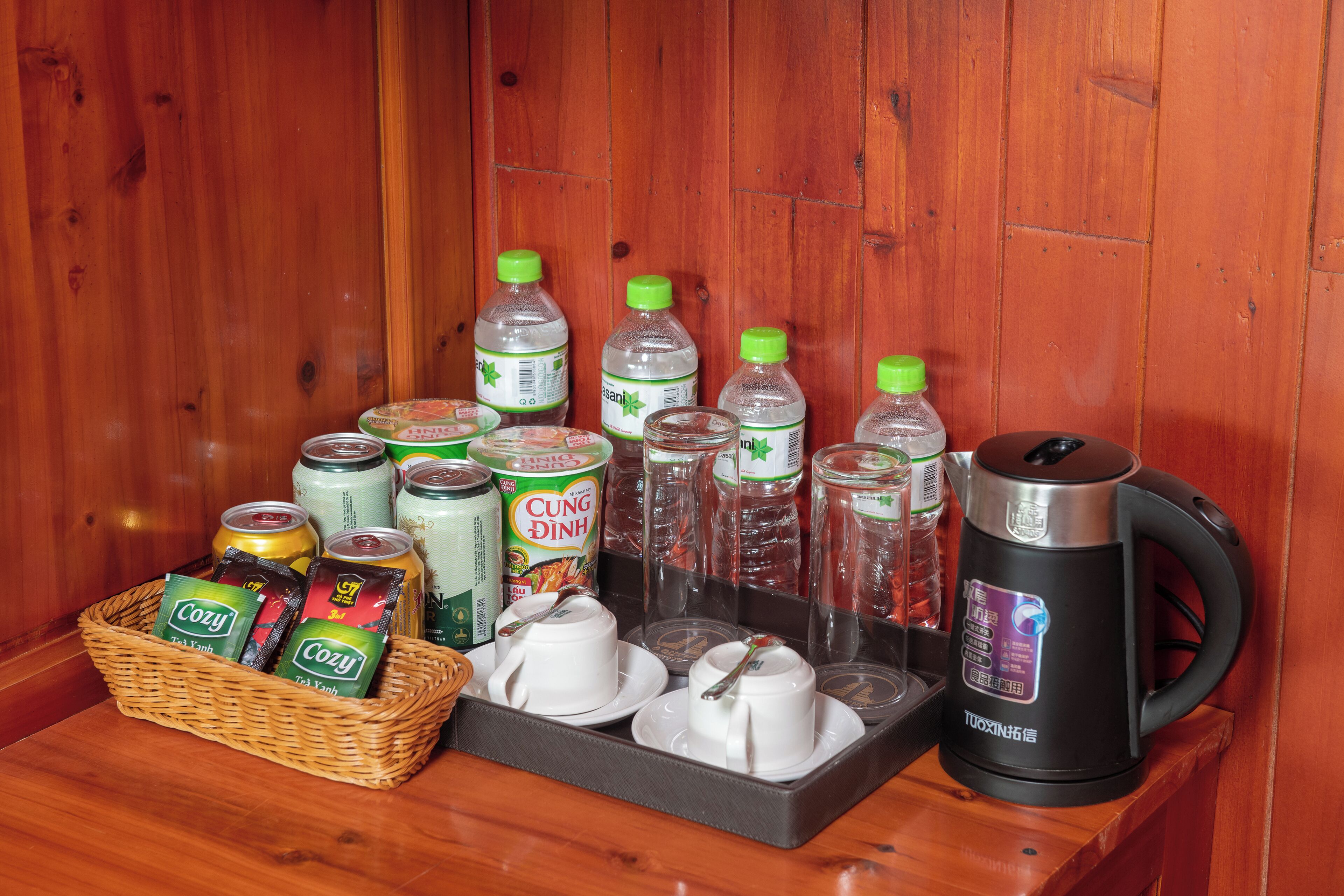 Interior de madera con una mesa que muestra diversas bebidas, como latas, botellas y una tetera.