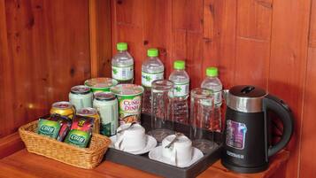 Interior de madera con una mesa que muestra diversas bebidas, como latas, botellas y una tetera.