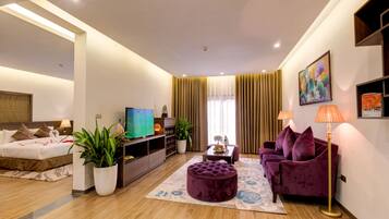 Executive suite, uitzicht op bergen | Woonkamer | Een lcd-televisie