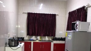 Cocina compacta con refrigerador, microondas, estufa y lavamanos.