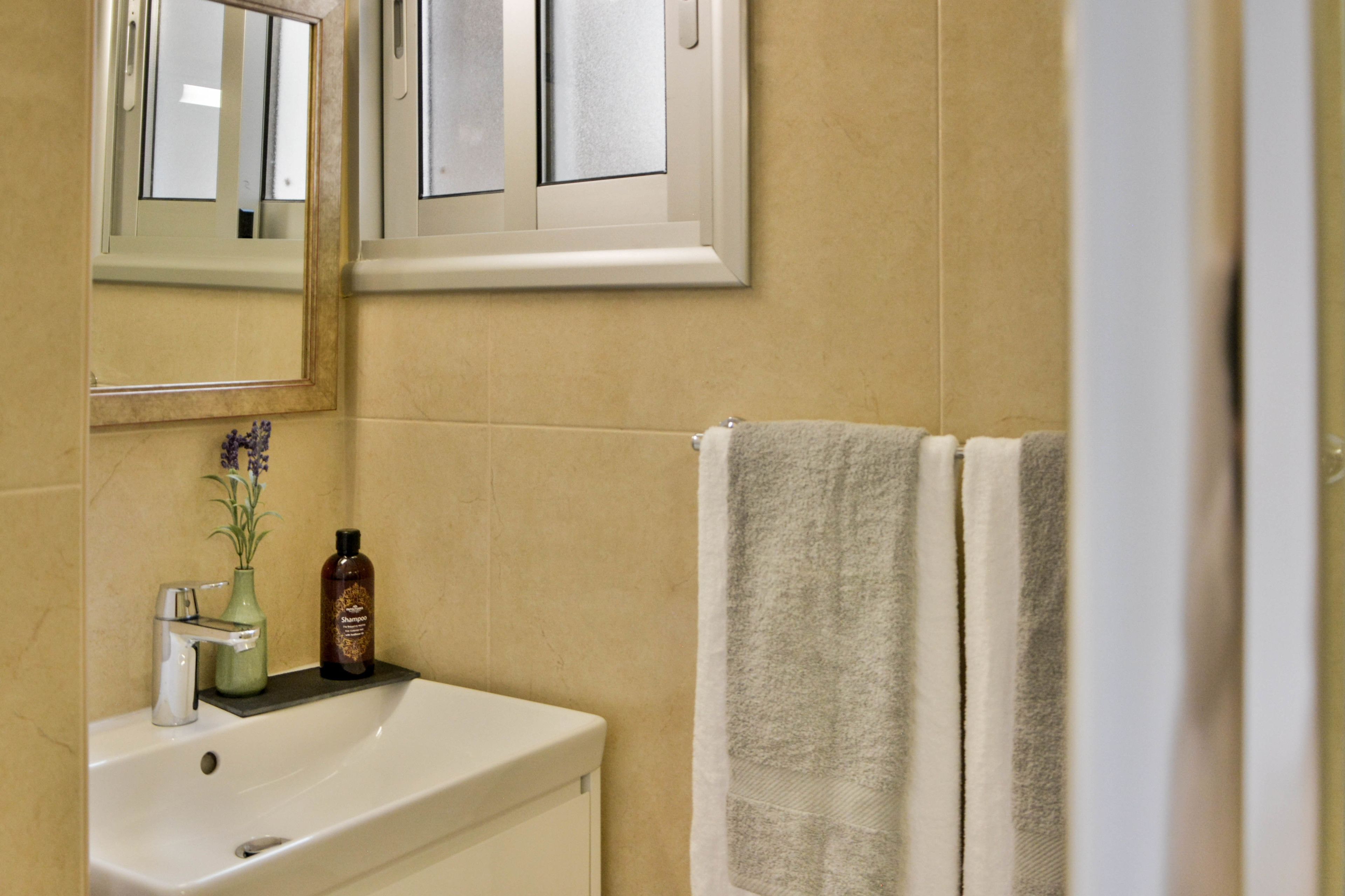 Ein Badezimmer mit Waschbecken, Spiegel und Handtuchhalter.