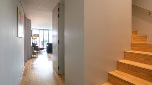 A modern hallway with wooden flooring and a staircase. - Porto Insight Apartment Cedofeita- Balcony & Parking (Porto)