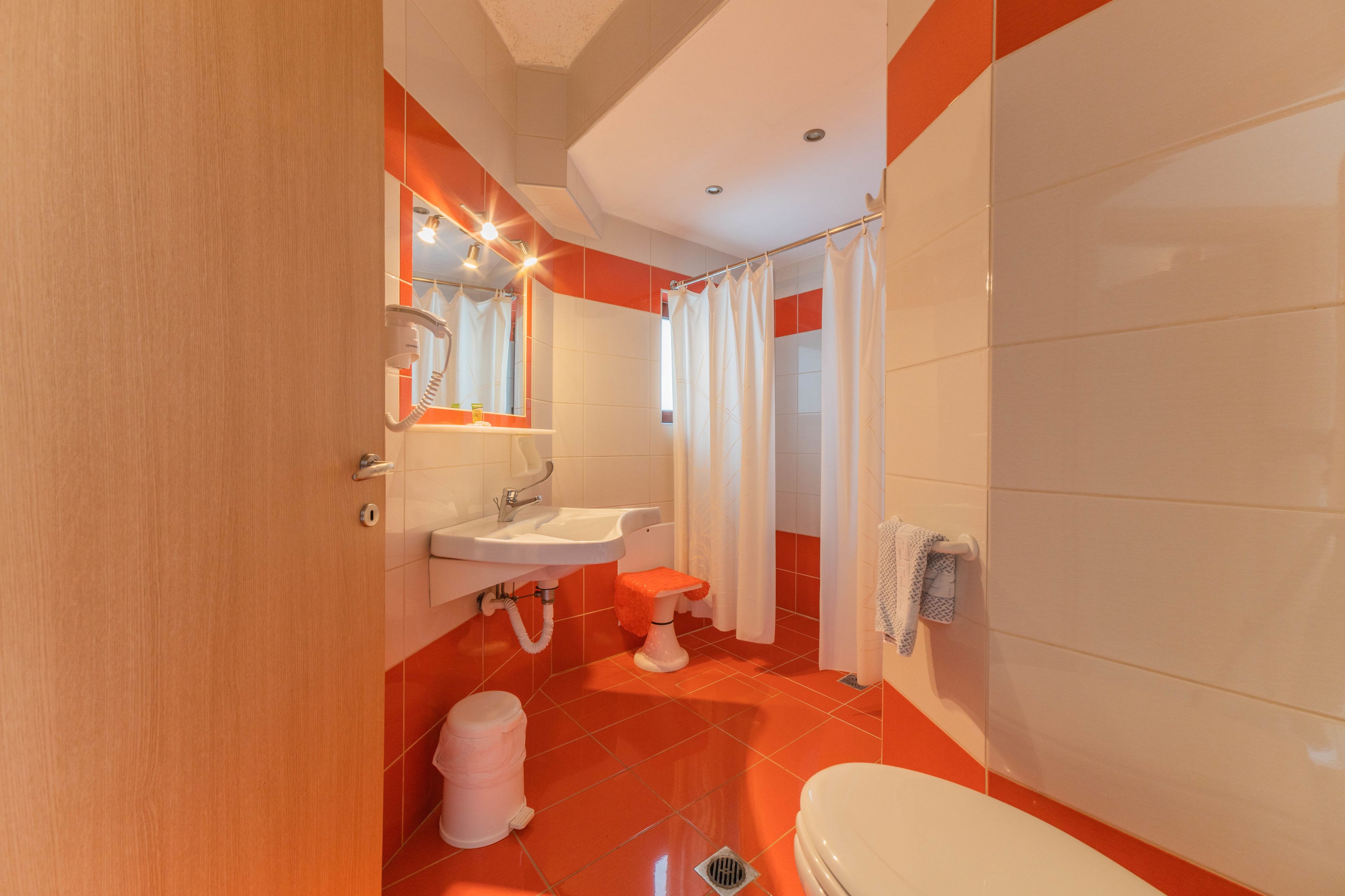 A bathroom with a toilet, sink, and shower curtain.