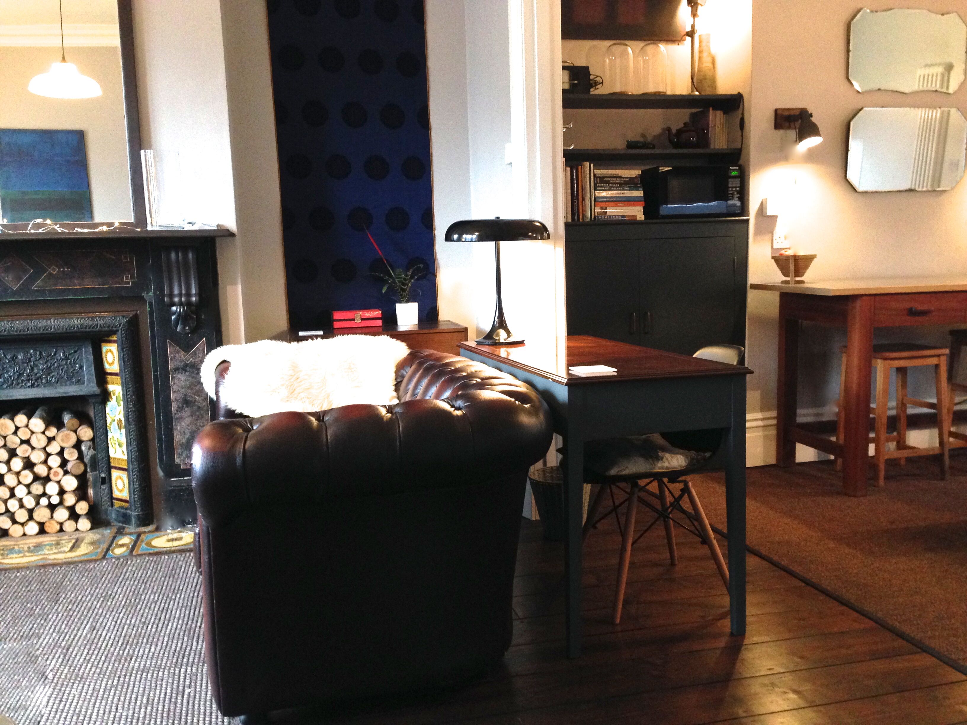 Una sala de estar acogedora con un sofá de cuero, una mesa de centro de madera y una chimenea.
