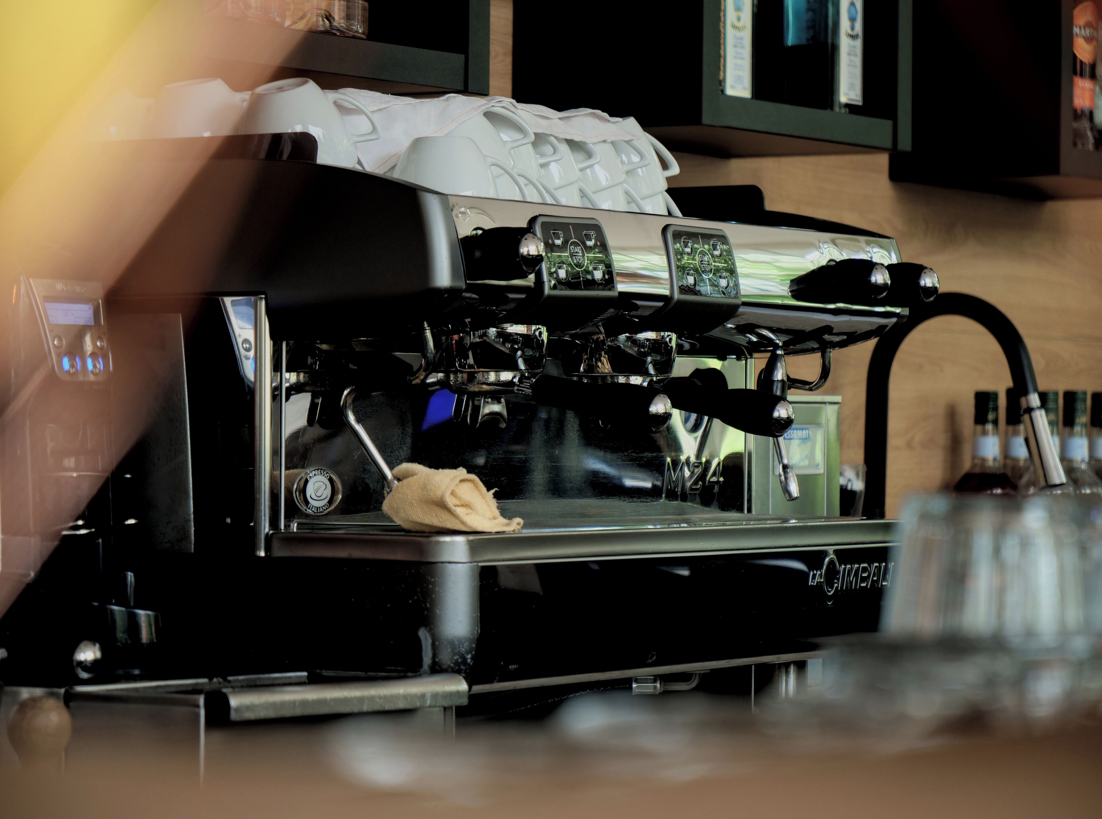 A coffee machine with a digital display and a cloth on the counter.