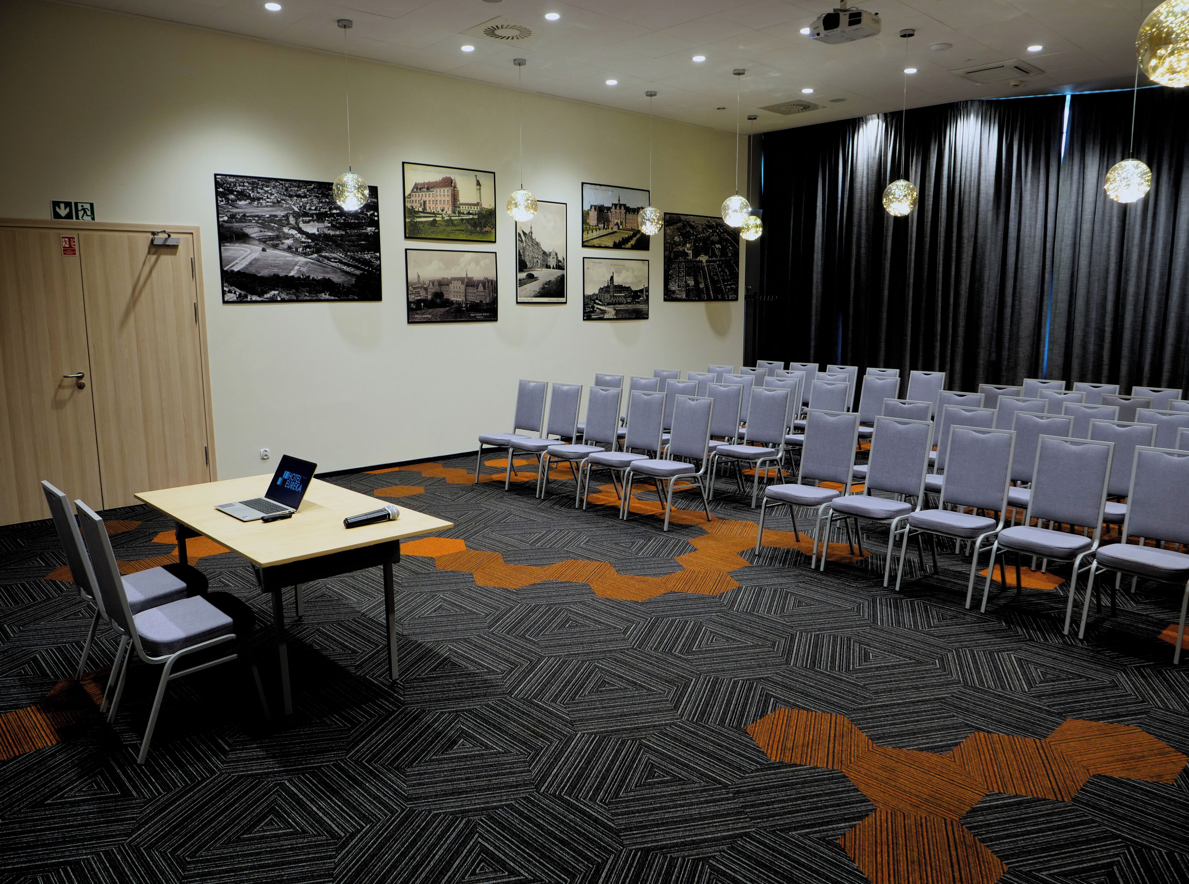 A conference room with a long table, multiple chairs, and a projector screen.