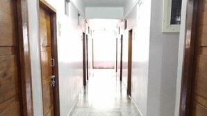 A hallway with wooden doors and a tiled floor.