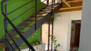 Eine Treppe mit grüner Wand und einem weißen Schrank mit dekorativen Fliesen.